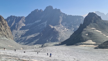 Flacher Gletscher mit Menschen und Bergen im Hintergrund | Bild: BR/Sebastian Kirchner