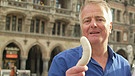 Christoph Schuster mit einer Weißwurst | Bild: Bayerischer Rundfunk