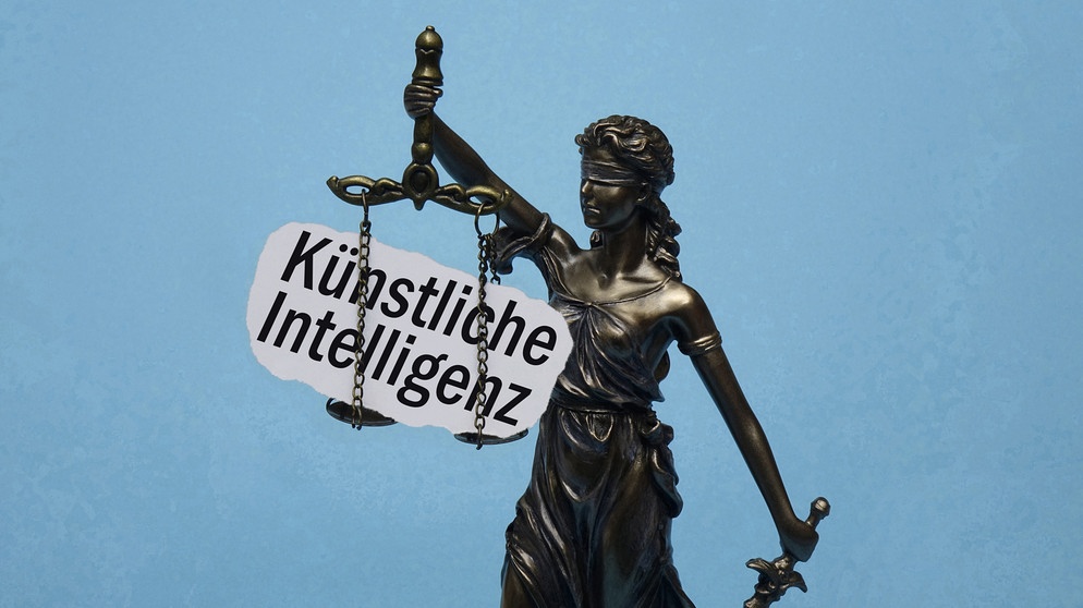 Das Modell der Justitia traegt den Schriftzug Kuenstliche Intelligenz. | Bild: picture alliance / ZB | Sascha Steinach