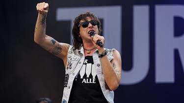 Marco Pogo, Sänger der Band Turbobier, auf der Bühne | Bild: picture alliance / FLORIAN WIESER / APA / picturedesk.com | FLORIAN WIESER